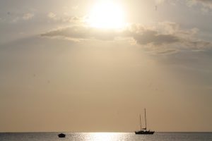 picture of a silhouette of a boat on the ocean in a Jamaican sunset
