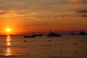 Beautiful orange Jamaican sunset with boats